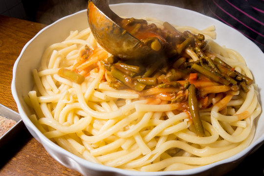Versamento sugo sulla pasta cotta scolata