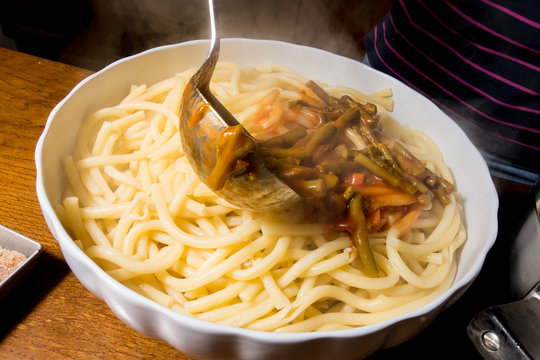 Versamento sugo sulla pasta cotta scolata
