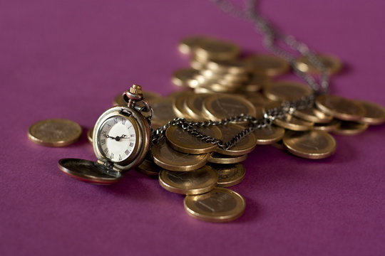 A chain watch and euros on a blurred purple background