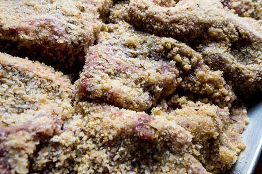 Costolette crude d&rsquo;agnello impanate pronte per la cottura