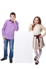 Little girl and boy beside a blank. Isolated on white background