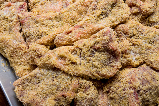 Costolette crude d&rsquo;agnello impanate pronte per la cottura