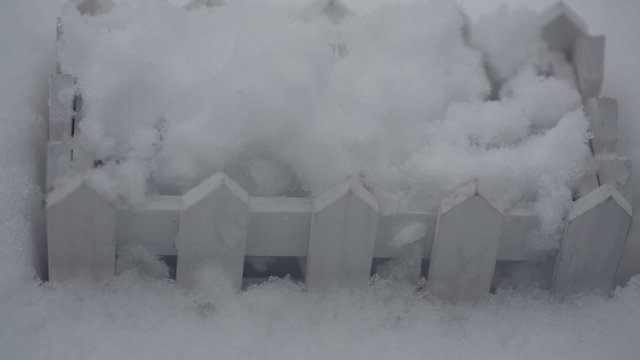 Decorative white wooden fence in the snow in winter close up