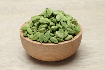 Cardamom pods in a wooden bowl