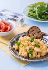 Scrambled eggs with fresh parsley on vintage metal plate
