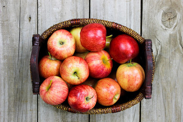 Basket of red apples on rustic wood background © laurha