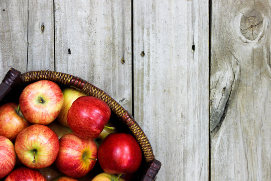 Basket of red apples on rustic wood background