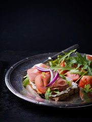 Open sandwiches with ham, tomato and arugula