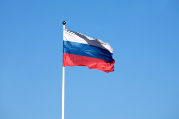 Russian flag on the flagpole waving on sky
