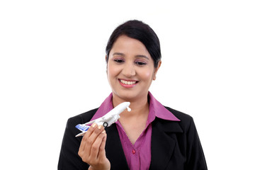 Cheerful businesswoman holding airplane miniature