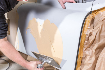 Obraz premium Spachtelarbeiten an einem Oldtimer Auto