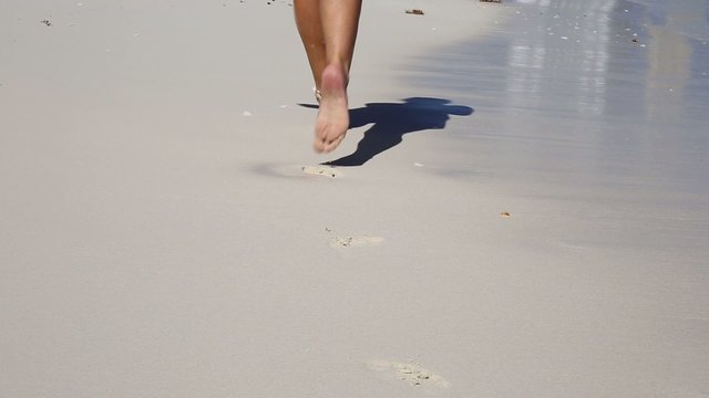 Beautiful woman legs, running along the beach
