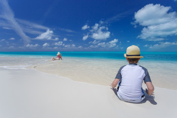 Family relaxing on at tropical beach in turquoise waters