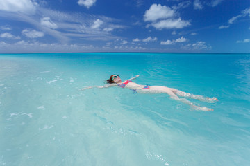 Woman floating on a back in the beautiful sea