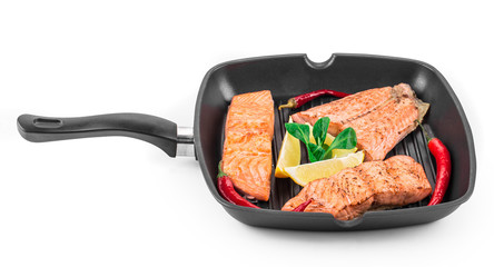 Fried salmon fillet in pan with lemon.