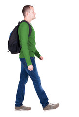 Fototapeta premium back view of walking man with backpack.