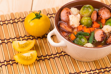 Fresh vegetable soup with sausage.