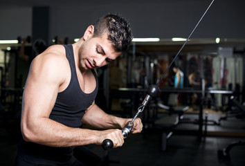 Biceps and triceps young man training at gym pull