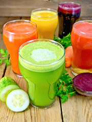 Juice cucumber and vegetable in glassful on board