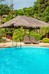 Beautiful luxury swimming pool with rattandeck chairs