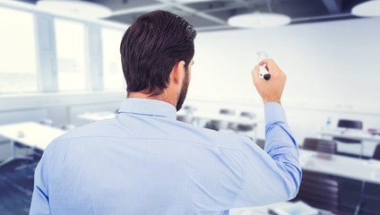 Composite image of businessman in suit writing with marker