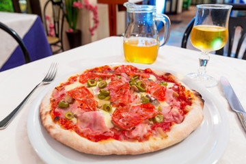 Italian pizza with ham, salami, cheese and green olives