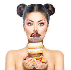 Beauty model girl taking stack of colorful donuts and muffin