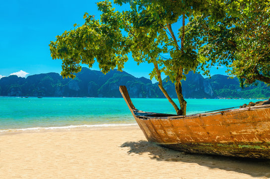 Wooden boat on the sandy shore of the exotic beach