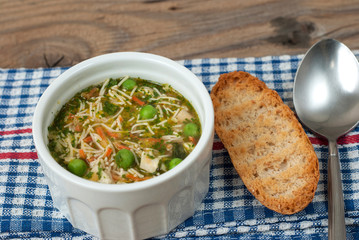 Soup with pasta and vegetables on old wooden table