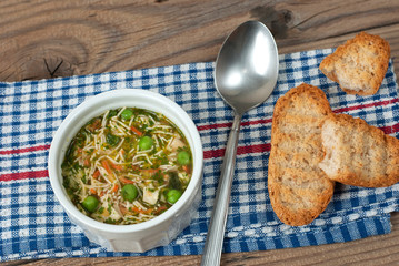 Soup with pasta and vegetables on old wooden table