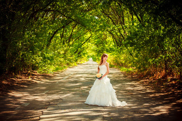 Beautiful bride with elegant white wedding dress with hand to he
