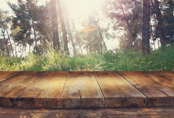 vintage wooden board table in front of dreamy and abstract fores