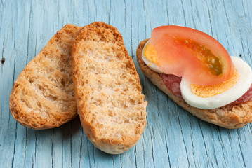 Rusk sandwich with salami, egg and tomato