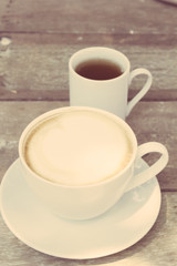 Cup of hot coffee and tea on wood table background