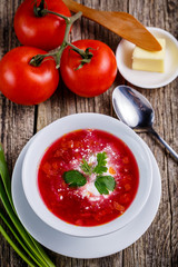 Tasty soup with bread on a wooden background.