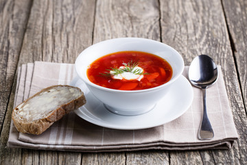 Tasty soup with bread on a wooden background.