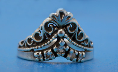 silver ring with a crown on blue