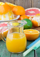 Orange juice in a jug and citrus on the table