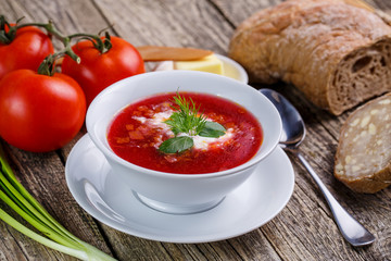 Tasty soup with bread on a wooden background.