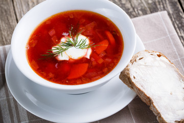 Tasty soup with bread on a wooden background.