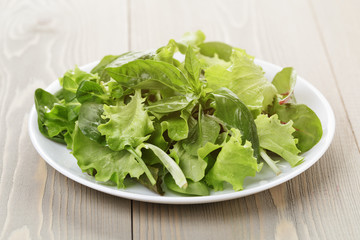 mix salad from different herbs on wooden table