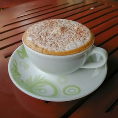 Coffee cup resting on a wooden table.
