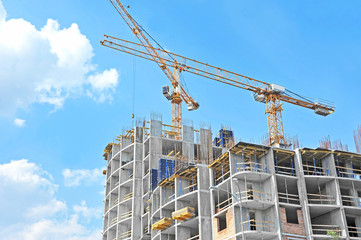 Crane and building construction site against blue sky