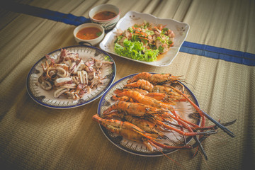 Homemade seafood lunch set include grilled prawns, grilled squids and seafood mix salad.