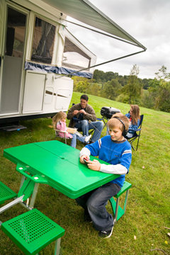 Camping: Family Sits Around Outside Of Camper
