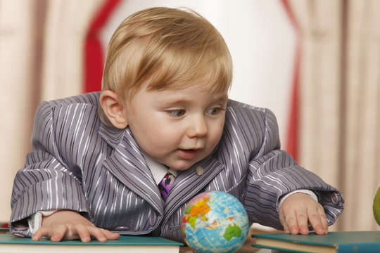 Baby boy with small globe and books
