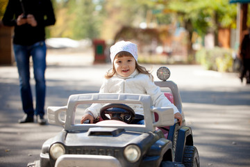 Naklejka premium happy little girl in a toy car