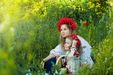 Mom and daughter in traditional Ukrainian costume in the forest