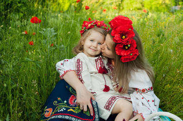 Mom and daughter in traditional Ukrainian costume in the forest