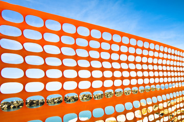 Orange plastic grid around a construction site on the coastline
